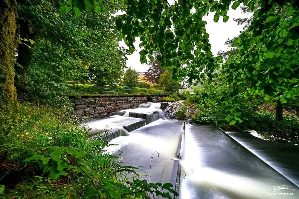 Fisketrapp ved Kaldvellfossen omgitt av grønn skog i Lillesand